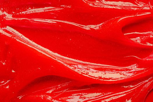 Red gel texture. Cosmetic clear liquid cream smudge. Skin care product sample closeup. Toothpaste or wax background