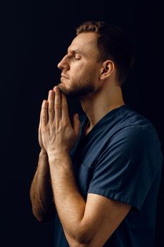 Man cover his face with his hands and thinks about life. Handsome man pray and believe in God. Orthodox Christian faith.