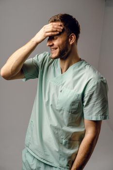 Surgeon weared in medical robe smile and posing on white background. Handsome happy doctor posing in studio