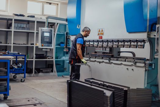 A smart factory worker or engineer makes machines in a production workshop. The concept of industry and engineering. Selective focus. High-quality photo