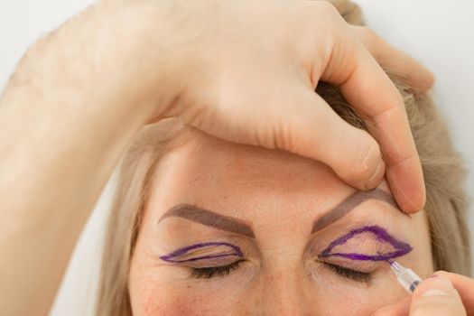 Blepharoplasty markup close-up on the face before the plastic surgery operation for modifying the eye region of the face in medical clinic. Doctor doing plastic cosmetic operation