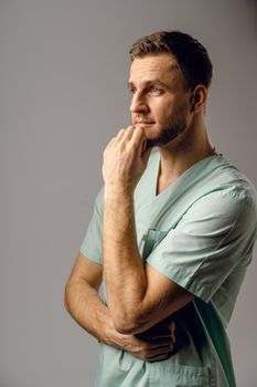 Surgeon weared in medical robe smile and posing on white background. Handsome happy doctor posing in studio