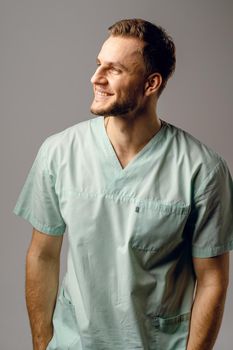 Surgeon weared in medical robe smile and posing on white background. Handsome happy doctor posing in studio