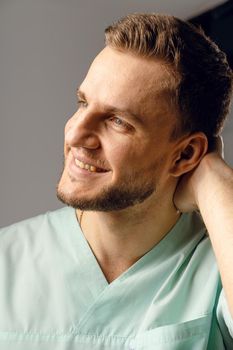 Surgeon weared in medical robe smile and posing on white background. Handsome happy doctor posing in studio