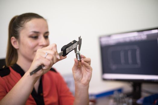 Within the heavy industry, a factory industrial engineer measures with a caliper and on a personal computer Designs a 3D model. High quality photo