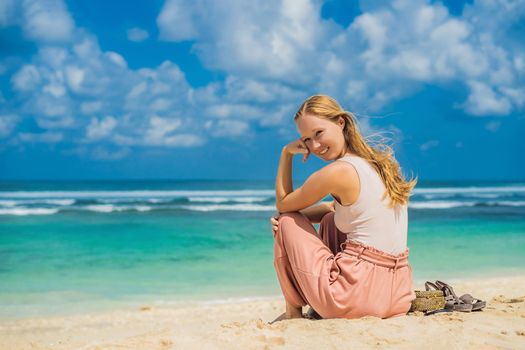 Young woman traveler on amazing Melasti Beach with turquoise water, Bali Island Indonesia.