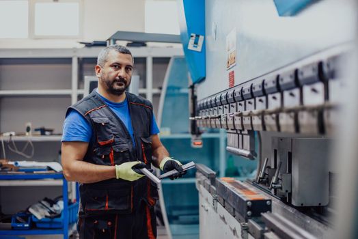 A smart factory worker or engineer makes machines in a production workshop. The concept of industry and engineering. Selective focus. High-quality photo