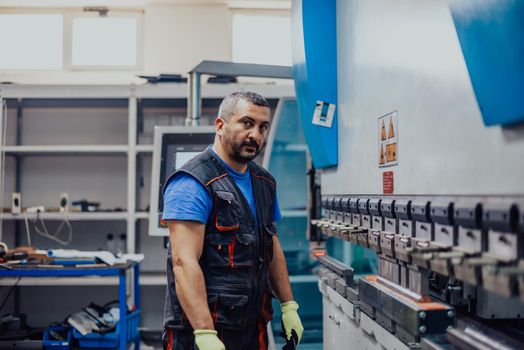 A smart factory worker or engineer makes machines in a production workshop. The concept of industry and engineering. Selective focus. High-quality photo