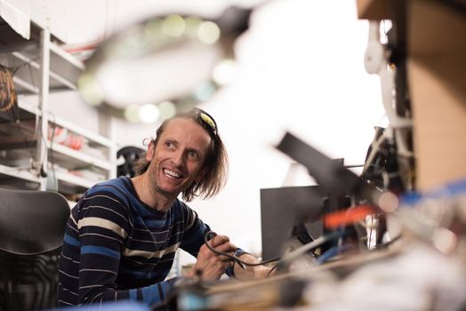 Industrial worker man soldering cables of manufacturing equipment in a factory. Selective focus. High quality photo