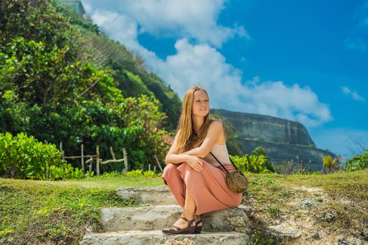 Young woman traveler on amazing Melasti Beach with turquoise water, Bali Island Indonesia.