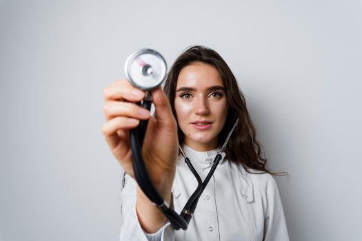 Medical student girl doing auscultation to patient. Doctor uses phonendoscope for auscultation. Medical therapy and treatment