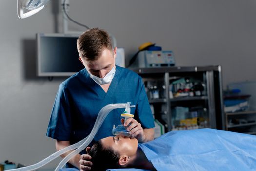 Anesthesiologist making ingalation anesthesia for patient. Doctor puts a mask on the patient before starting operation.