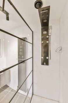 The interior of a modern bathroom with a glazed shower cabin in a cozy apartment