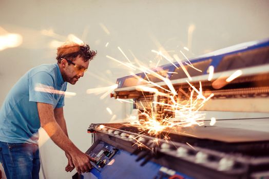 Within heavy industry. A man works in a modern factory on a CNC machine. Selective focus. High-quality photo