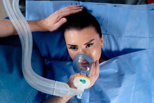 Treatment of a severe form of coronovirus covid-19. The doctor puts on a mask for artificial ventilation of the lungs in the intensive care unit.