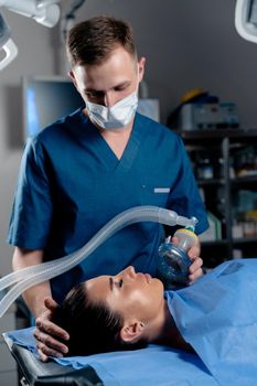 Treatment of a severe form of coronovirus covid-19. The doctor puts on a mask for artificial ventilation of the lungs in the intensive care unit.