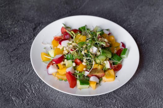 Wheat germ salad, tomatoes, peppers, radish, cucumber, olive oil. Vegetable salad on white plate on gray background.