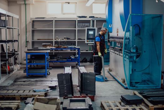 A smart factory worker or engineer makes machines in a production workshop. The concept of industry and engineering. Selective focus. High-quality photo