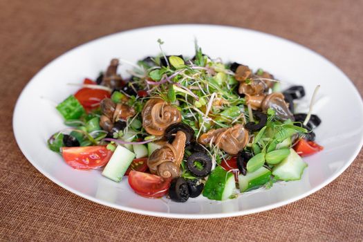 Salad with snail, olive, tomatoe cherie, cucumber and greens.