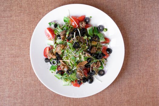 Salad with snail, olive, tomatoe cherie, cucumber and greens.