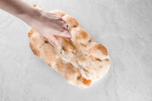 Touching and checking quality dough for pinsa romana on light background. Gourmet italian cuisine