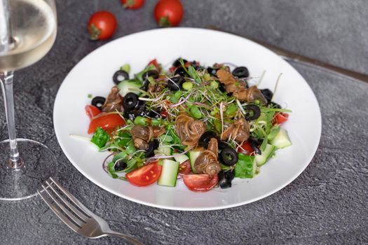 Salad with snail, olive, tomatoe cherie, cucumber, greens on dark background