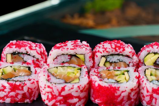 California rolls with caviar, salmon and avocado, cucumber, nori close-up