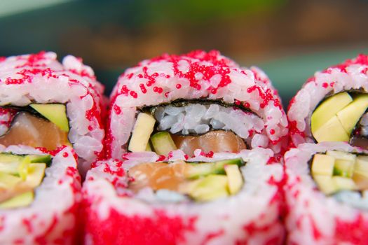 California rolls with caviar, salmon and avocado, cucumber, nori close-up