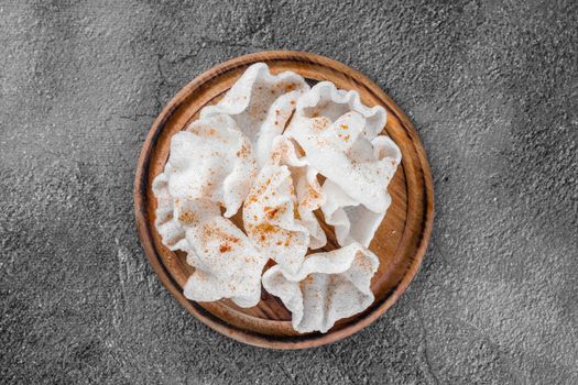 Rice chips on a wooden board on a gray background. Top view