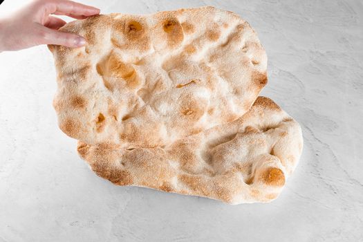 Touching and checking quality dough for pinsa romana on light background. Gourmet italian cuisine