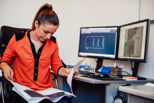 Within the heavy industry, a factory industrial engineer measures with a caliper and on a personal computer Designs a 3D model. High quality photo