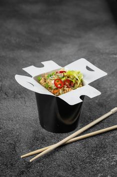 Rice in wok box for food delivery. Asian spicy dish for street restaurant and fast food cafe.