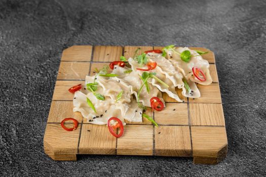 Jiaozi chinese dumplings named gyoza on wooden plate. Asian traditional fast food. Dough dish stuffed with meat and vegetables, less often only meat