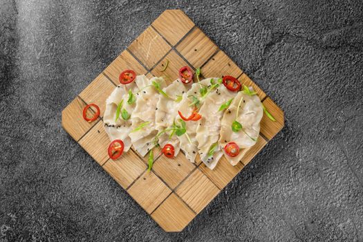 Jiaozi chinese dumplings named gyoza on wooden plate. Asian traditional fast food. Dough dish stuffed with meat and vegetables, less often only meat