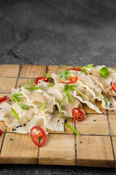 Jiaozi chinese dumplings named gyoza on wooden plate. Asian traditional fast food. Dough dish stuffed with meat and vegetables, less often only meat