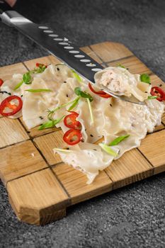 Jiaozi chinese dumplings named gyoza on wooden plate. Asian traditional fast food. Dough dish stuffed with meat and vegetables, less often only meat