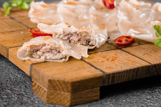 Jiaozi chinese dumplings named gyoza on wooden plate. Asian traditional fast food. Dough dish stuffed with meat and vegetables, less often only meat