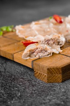 Jiaozi chinese dumplings named gyoza on wooden plate. Asian traditional fast food. Dough dish stuffed with meat and vegetables, less often only meat