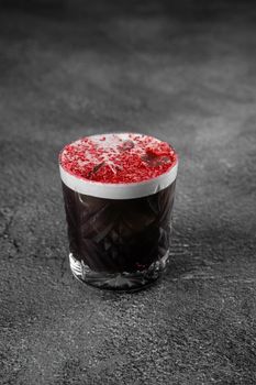 Cocktail with cola, cream, ice, freeze-dried strawberry powder on a gray background. Alcoholic coffee drink