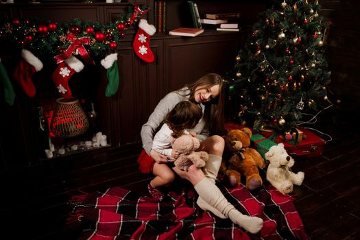 Mother and daughter preparing for christmas celebration. Having fun with family near new year tree. Pregnant woman with daughter