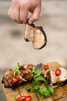 Fried ribs on a wooden plate on a gray background. Barbecue decoration parsley and chili