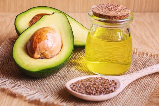 Avocado and avocado oil on wooden background. Selective focus.food