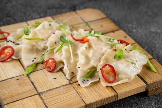 Jiaozi chinese dumplings named gyoza on wooden plate. Asian traditional fast food. Dough dish stuffed with meat and vegetables, less often only meat