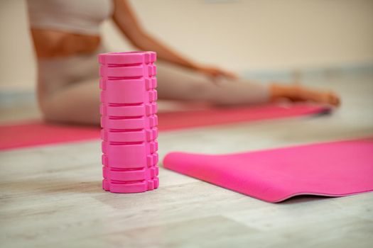 Fitness, pilates stretching exercises, a woman in beige sportswear, trains in a sports club