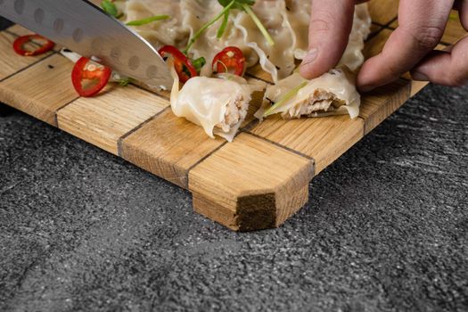 Jiaozi chinese dumplings named gyoza on wooden plate. Asian traditional fast food. Dough dish stuffed with meat and vegetables, less often only meat