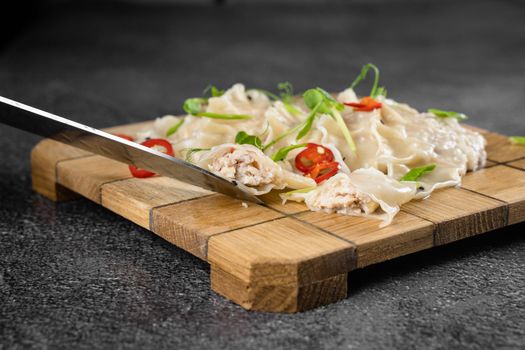 Jiaozi chinese dumplings named gyoza on wooden plate. Asian traditional fast food. Dough dish stuffed with meat and vegetables, less often only meat