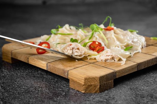 Jiaozi chinese dumplings named gyoza on wooden plate. Asian traditional fast food. Dough dish stuffed with meat and vegetables, less often only meat