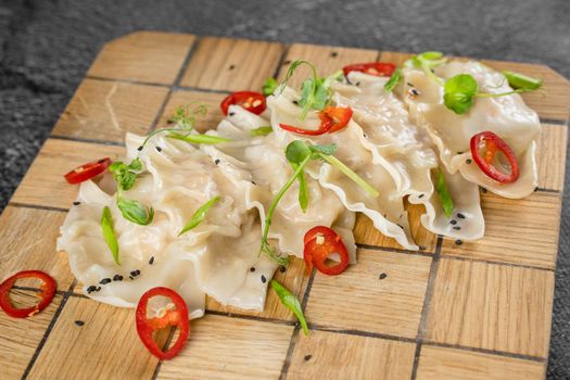 Jiaozi chinese dumplings named gyoza on wooden plate. Asian traditional fast food. Dough dish stuffed with meat and vegetables, less often only meat