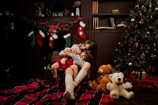 Mother and daughter preparing for christmas celebration. Having fun with family near new year tree. Pregnant woman with daughter