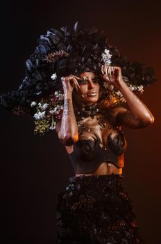 Portrait of a model in a headdress and dress made of coal.
